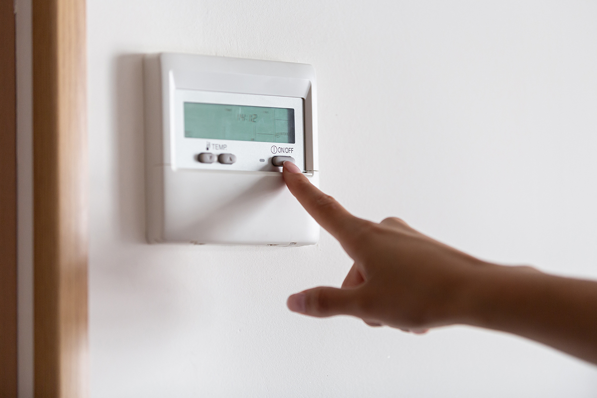 Woman adjusting her thermostat