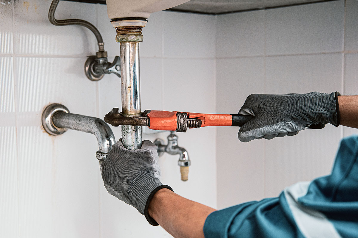 Orcutt plumber using wrench to repair sink